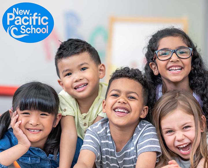 Happy kids smiling in a classroom setting with the New Pacific School logo